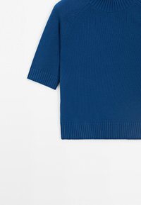 Modrý krátký pletený svetr s žebrovanými manžetami, lemem a kulatým výstřihem na bílém pozadí.