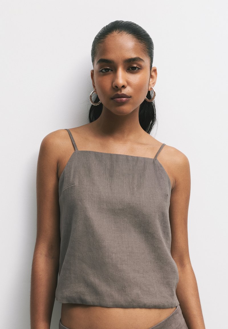 Barna, lenből készült camisole vékony pántokkal és négyzet alakú dekoltázzsal. Simító textura, rövidített fazon, minimalista dizájn, nincs észlelhető mintázat.