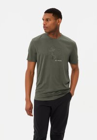 T-shirt vert à manches courtes en tissu doux, présentant un graphique de montagne et un chemin sinueux, avec le logo "VAUDE" en blanc en bas.