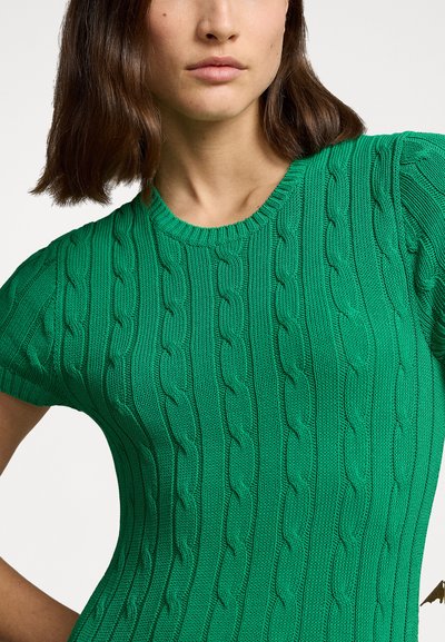 Suéter corto de manga corta tejido en verde que presenta un patrón de cable texturizado y un cuello redondo, destacando una silueta ajustada.