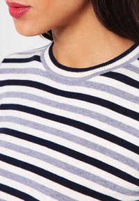 Suéter de punto a rayas con líneas horizontales en navy, gris claro y blanco. Cuello redondo acanalado y textura suave.