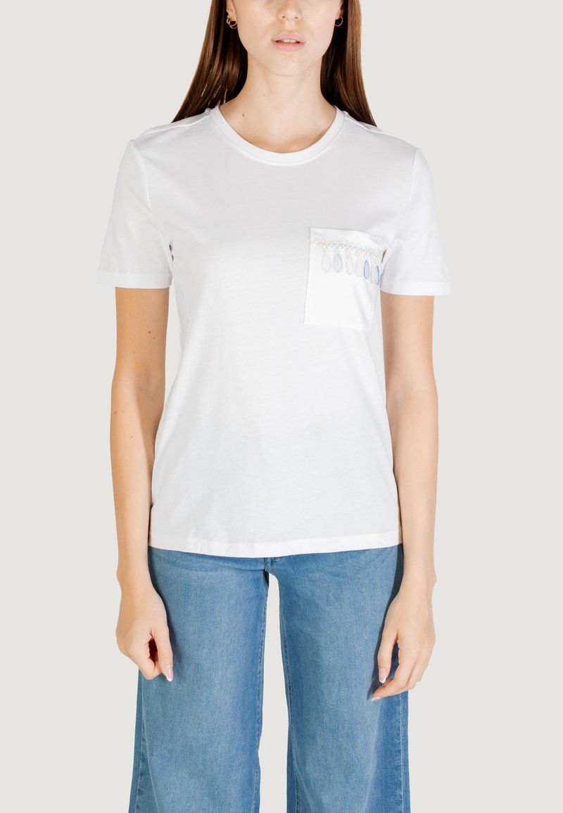 Camiseta de algodón blanca con mangas cortas, escote redondo y un bolsillo que presenta patrones de gotas de color a lo largo del borde superior.