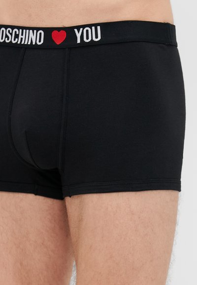 Boxers em algodão preto com um design ajustado, apresentando uma cinta elástica vermelha e branca que diz "MOSCHINO ❤️ YOU."