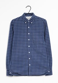 Camicia a maniche lunghe a quadri blu e navy con colletto a punta, taschino frontale e bottoni bianchi, appesa a un gancio nero.