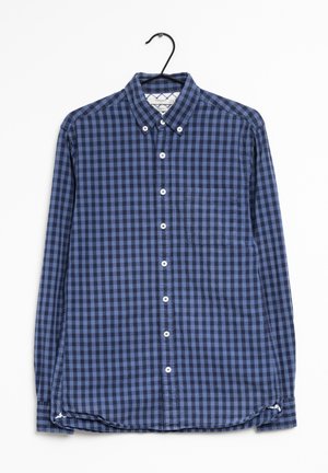 Blau- und marineblau kariertes Langarmhemd mit Button-Down-Kragen, Brusttasche und weißen Knöpfen, hängt an einem schwarzen Haken.