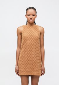 Adīta kleita gaiši brūnā krāsā ar dimanta rakstu, bez piedurknēm un taisnu apakšmalu, izgatavota no teksturētas auduma.