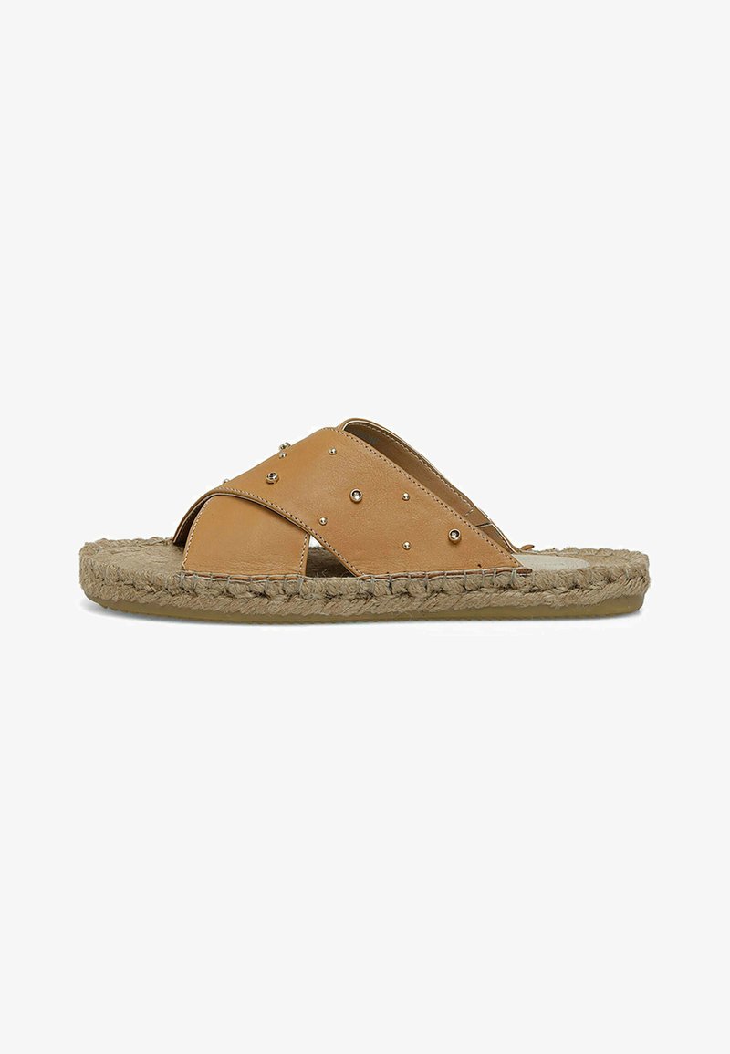Brune læderslide sandaler med krydssnøre, prydet med sølvnitter og en vævet jutesål for tekstur og komfort.