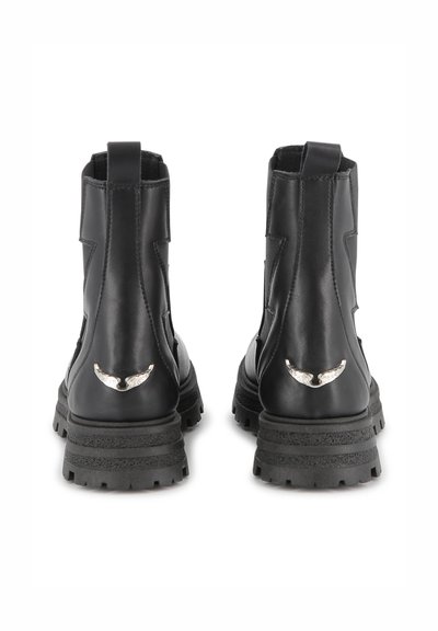 Svarta läderankelboots med en texturerad yta, tjock gummisula och silverfärgade vingeformade detaljer på baksidan.