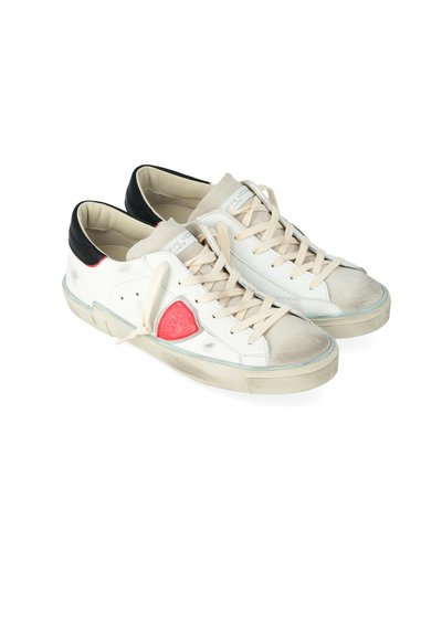 Sneaker in pelle bianca con lacci beige, tallone nero, patch con logo rosso sul lato, dettagli usurati sulla punta e nelle aree della suola, affiancati.