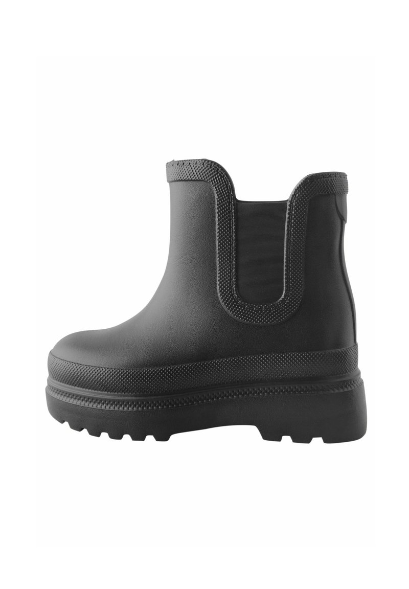 Botte de cheville en caoutchouc noir avec un talon texturé et surélevé, des panneaux latéraux élastiques et un bout lisse et arrondi. Semelle antidérapante pour une meilleure adhérence.