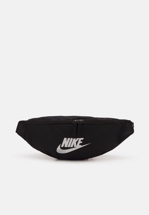 Marsupio in nylon nero con due scomparti con cerniera, caratterizzato da un prominente logo Nike bianco e un design elegante e aerodinamico.