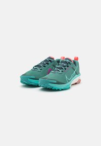 Grüne Trailrunning-Schuhe mit einem strukturierten Mesh-Obermaterial, pinken Akzenten, einer gepolsterten Sohle mit gesprenkelten Details und strapazierfähiger Traktion.