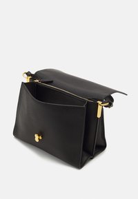 Borsa a mano in pelle nera con superficie testurizzata, caratterizzata da una chiusura con zip e dettagli in oro. È dotata di una tasca frontale piatta.