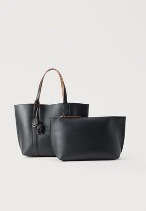 Black leather tote bag with tan handles and matching black zippered pouch with subtle brand embossing on plain background.