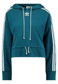 Teal cropped hoodie med vita dragsnören och tre vita ränder på ärmarna. Har en adidas-logotyp på bröstet. Mjuk tygtextur.