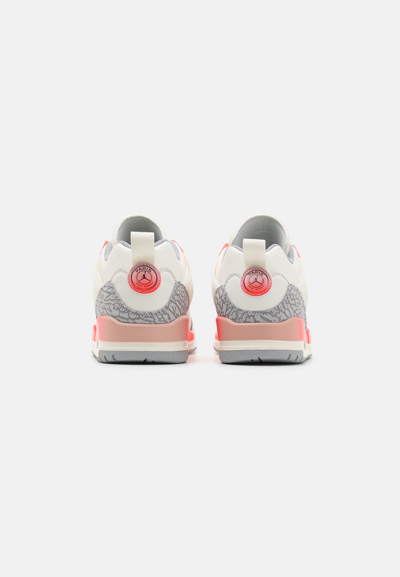 Weiße und rosa Sneaker mit einer strukturierten grauen Ferse, kreisförmigem Logodetail und glatter Verarbeitung sowie einer Zuglasche auf der Rückseite.
