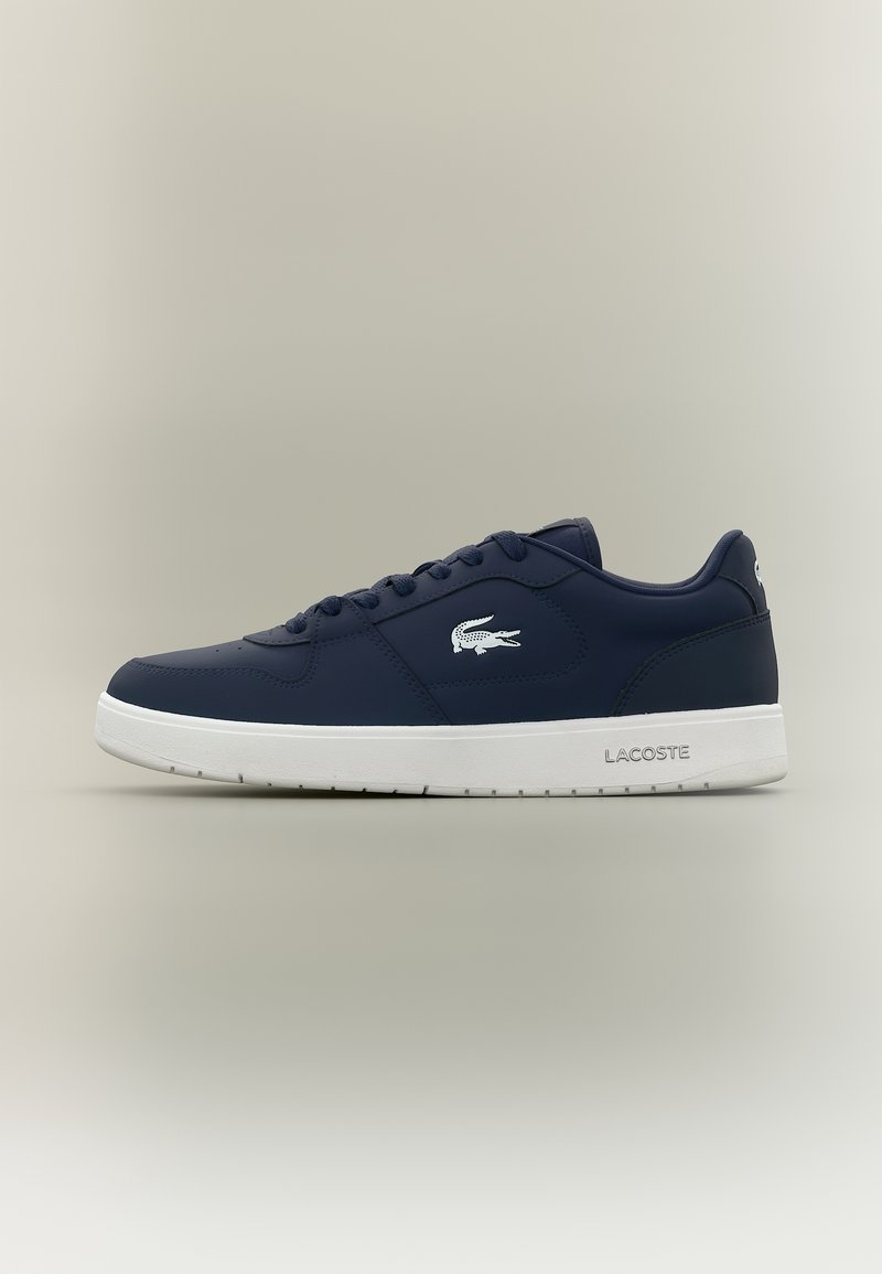 Baskets Lacoste bleu marine avec logo blanc sur le côté et semelle blanche, design bas, fermeture à lacets, vues de profil gauche.