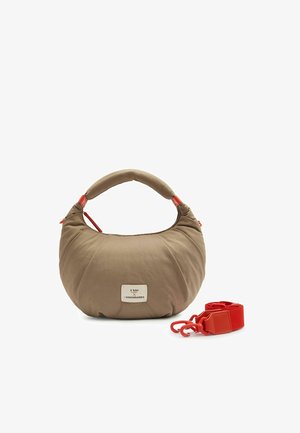 Beige crescent-shaped handbag with padded handle, red zipper accents, a detachable red shoulder strap, and a front logo patch.