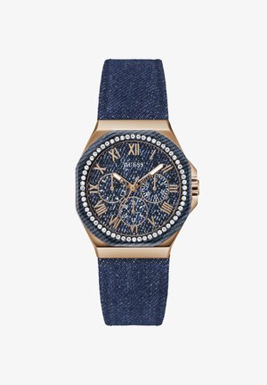 Denim remwatch med et gyldent oktogonalt urkasse, blå denim urskive, romerske tal, sub-ure og en krystal bezel for ekstra detaljer.