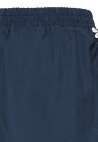 Shorts à taille élastique bleu marine avec tissu froncé et un petit détail papillon blanc sur le côté.