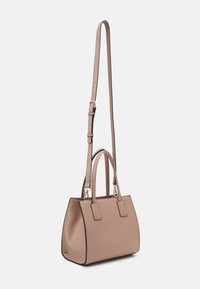 Beige handväska med en strukturerad form, ovandelshandtag och en avtagbar axelrem. Har svart kant och gulddetaljer.