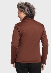 Braune Softshelljacke mit hohem Kragen, sanfter Textur und leichtem Glanz. Verfügt über ein dezentes Logo auf der Rückseite und eine taillierte Passform.