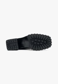 Black rubber sole with deep treads and cross patterns. Features a smooth surface and slight heel for traction and stability.