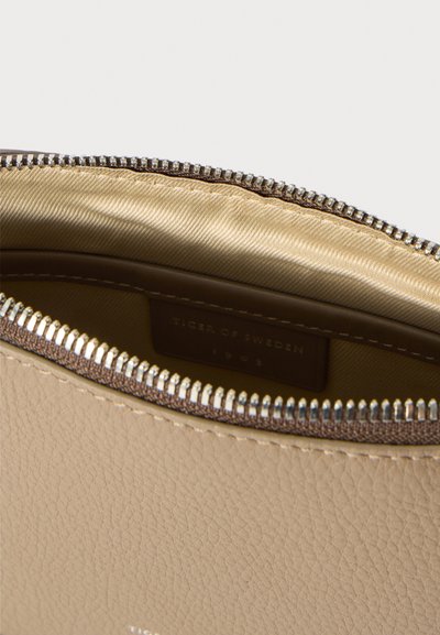 Pochette in pelle beige con superficie testurizzata, fodera in satin dorato e zip argentata. L'interno presenta un'etichetta di marca.