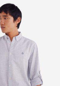 Blauwe en witte gestreepte overhemd met een spread collar, lichte stof, opgerolde mouwen en een klein geborduurd logo op de borst.