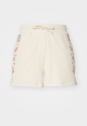 Kremastosve boje rebraste šortsice s elastičnim pojasom, ukrašene smešnim smešnim cvjetnim i geometrijskim uzorcima sa strane.