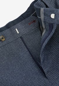 Hosen aus einer Wollmischung mit einem strukturierten dunkelblauen Muster, ausgestattet mit einem Knopfverschluss, Reißverschluss und einem roten Akzentstich am Bund.