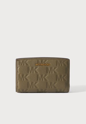 Alyvuogių žalumos tekstūruota Michael Kors piniginė su iškiliais MK raštais ir auksiniu logotipu viduryje priekinėje dalyje, pateikta prieš paprastą šviesią foną.