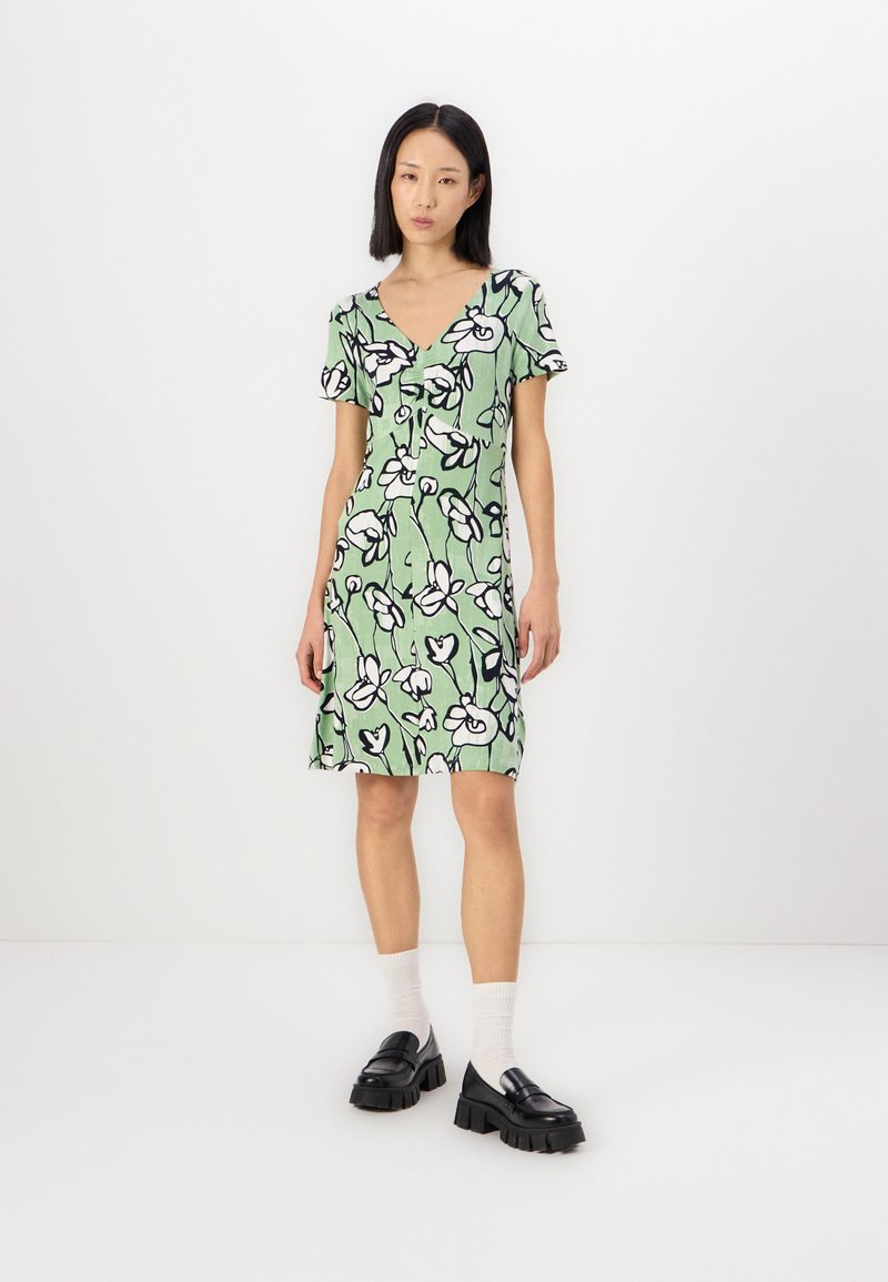 Rochie florală verde cu mâneci scurte și decolteu în V, având contururi negre ale florilor. Textură netedă și design până la genunchi.