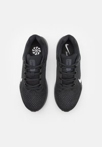 Schwarze Sportschuhe mit einem Obermaterial aus Netzgewebe, strukturiertem Design, weißem Swoosh-Logo und schwarzen Schnürsenkeln. Ausgestattet mit einer konturierten Sohle für Komfort.