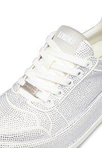 Sneaker bianche con un design testurizzato, dotate di strass argento, lacci in tessuto e un logo in gomma trasparente sul tallone.