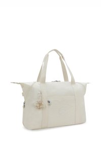 Beige canvas tote bag met twee handvatten aan de bovenkant, ritssluiting, voorvak en een decoratieve hanger. Heeft een circulair logo aan de zijkant.