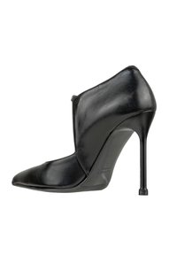 Stivale alla caviglia in pelle nera con tacco a stiletto, punta affusolata e tacco alto e sottile, visto di lato su uno sfondo bianco.