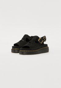 Sandale platform din suede negru, cu un design floral decupat, curea la gleznă cu cataramă de ton auriu și cusătură galbenă pe talpă.