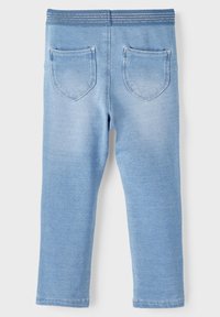 Light blue cotton blend leggings featuring a textured elastic waistband, two back pockets, and a slim fit design with tapered legs.
