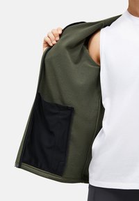 Fleece zip-up jacket in olive green, featuring a soft texture and a black interior pocket. Open front displays the lining detail.