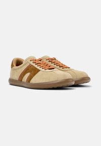 Beige mockasin sneakers med bruna accenter, har rund tå, snörningsdesign och flexibla gummisulor. Texturerade ytor lägger till detaljer.