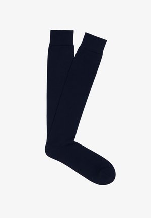 Calzini al ginocchio blu navy realizzati in tessuto morbido e stretch con polsini a costine. Progettati con una trama liscia e una forma aderente per il massimo comfort.