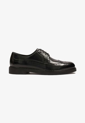 Scarpa da uomo in pelle nera con punta arrotondata, design con lacci, dettagli brogue, texture liscia e suola piatta in gomma.