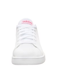 Zapatilla deportiva blanca con un upper sintético suave, puntera redondeada, suela blanca plana y logo rosa de "adidas" en la lengüeta. Cintas con textura.