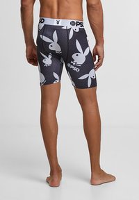 Boxers noirs avec un motif de logos de lapins blancs. Dotés d'une ceinture blanche unie portant l'inscription "PSD". Fabriqué en matériau extensible.