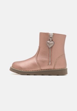 Bottine enfant en or rose avec fermeture éclair latérale et languette en forme de cœur, semelle plate beige et texture cuir lisse.