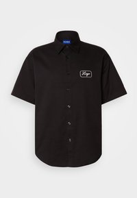 Zwart kortom shirt van katoen, met een knoopsluiting aan de voorkant en het geborduurde "Hugo" logo op de linkerborst. Gladde textuur.