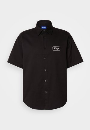 Črna majica s kratkimi rokavi iz bombaža, z gumbi na sprednji strani in vezenim logotipom "Hugo" na levem prsnem delu. Gladka tekstura.