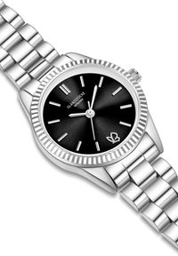 Sudraba metāla rokas pulkstenis ar melnu ciparnīcu, trim sudraba rādītājiem, teksturētu jeršu un tauriņa logotipu pulkstenis sešos. Eleganta saite aproce.