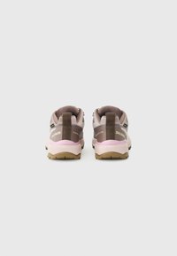 Bruine en lichtroze wandelschoenen met een gestructureerde bovenkant, verstevigde hiel en een rubberen buitenzool. Beschikt over een logo aan de zijkant en verstelbare veters.